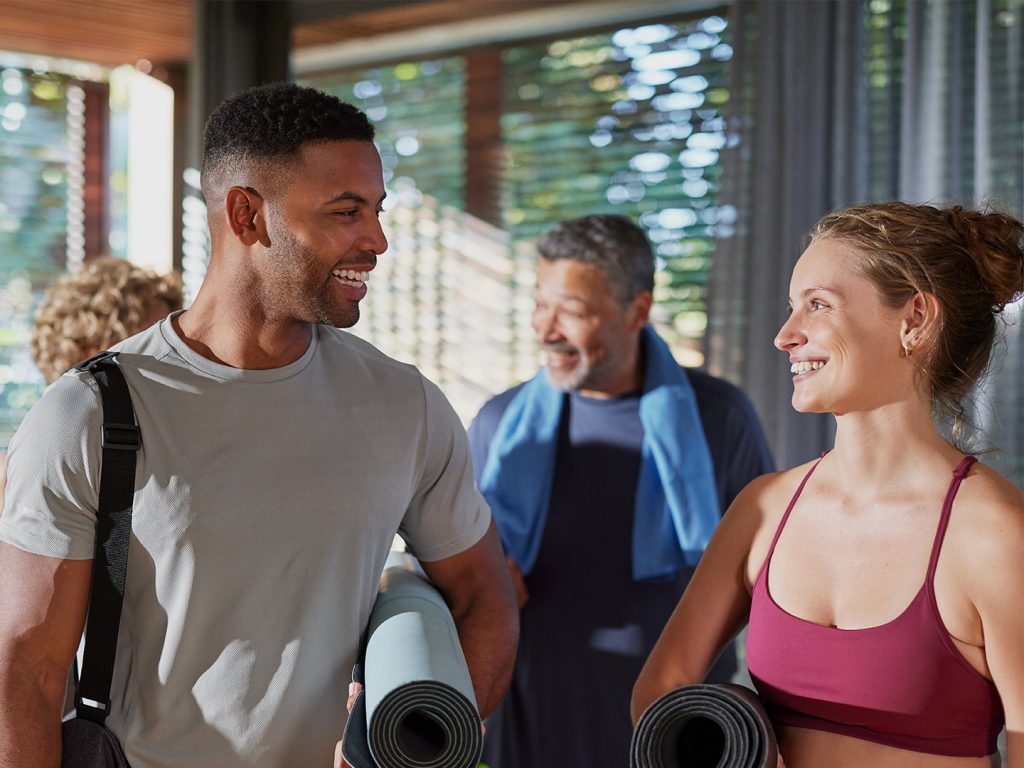 Man and woman holding yoga mats