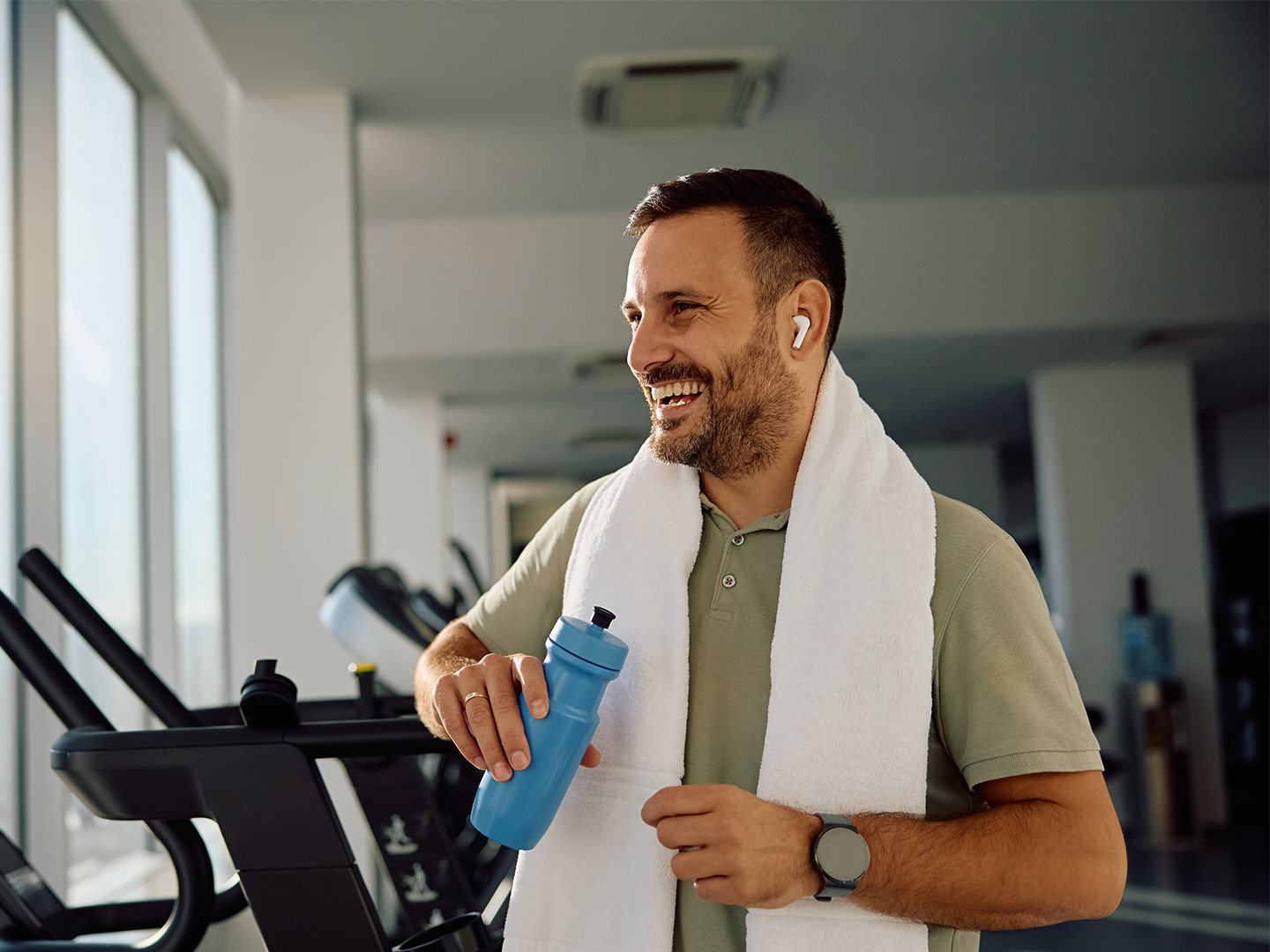 Man in gym with water bottle and towel
