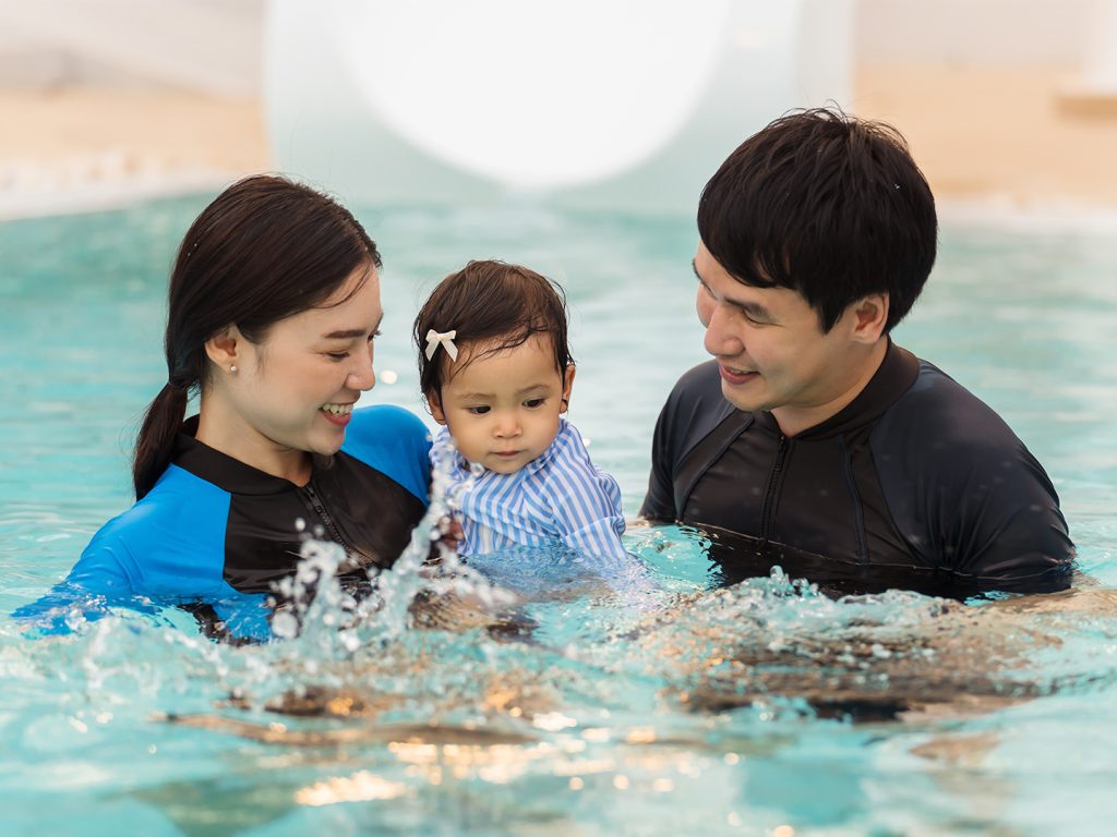 Mum and dad with toddler in pool