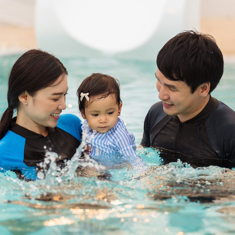 Mum and dad with toddler in pool