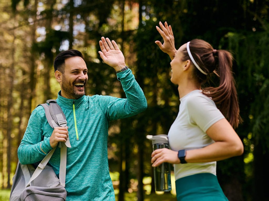 Man and woman in gym gear give each other high-five