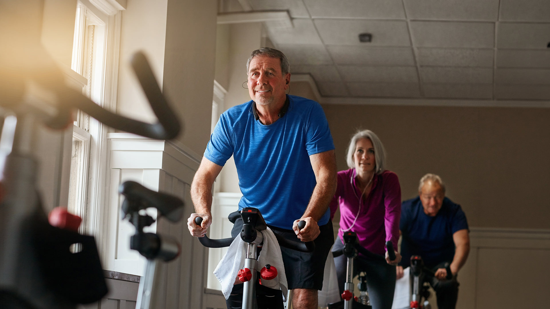 Older men and woman riding an exercise bike